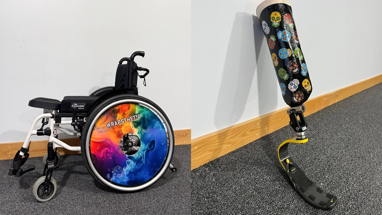 A wheelchair featuring a vibrant rainbow Wrapsthetic wheel cover and a prosthetic leg with a colorful sugar skull wrap.webp