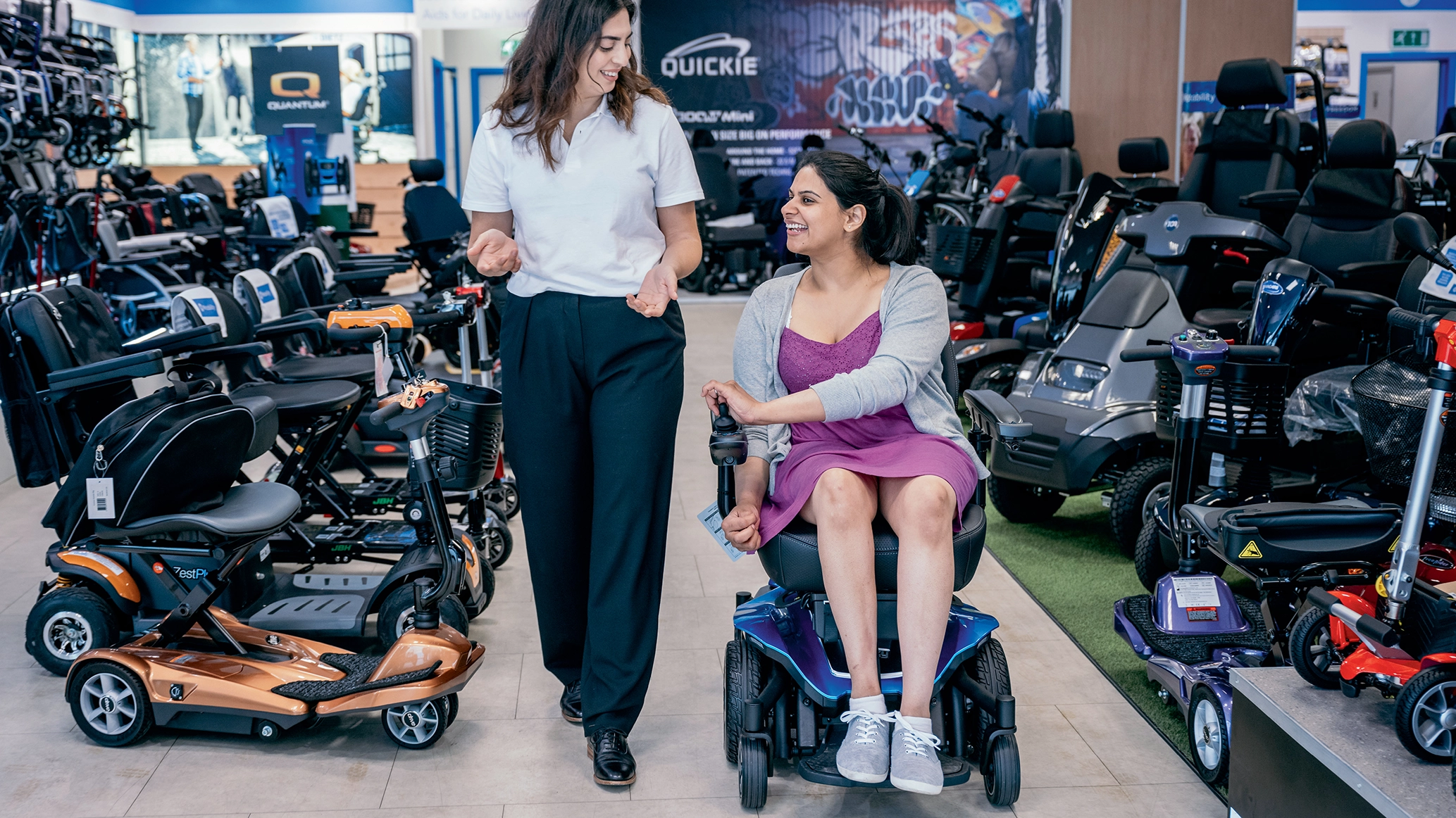 a-mobility-scooter-user-being-shown-around-a-wheelchair-and-scooter-store-by-a-member-of-staff.webp