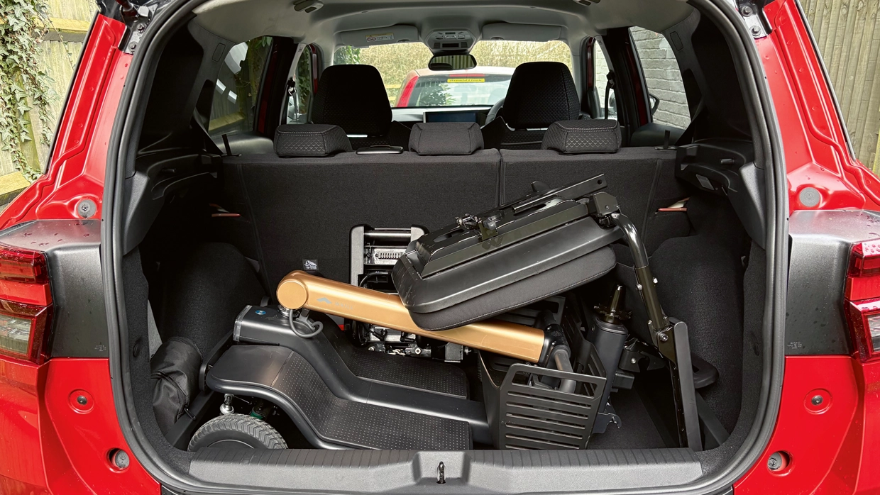 folded-mobility-scooter-stored-in-the-boot-of-a-red-vauxhall-frontera-electric-suv-with-the-rear-seats-in-an-upright-position.webp