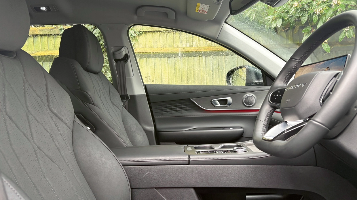 interior-of-a-chery-tiggo-8-front-cabin-featuring-grey-quilted-front-seats-textured-door-panels-and-red-ambient-lighting.webp