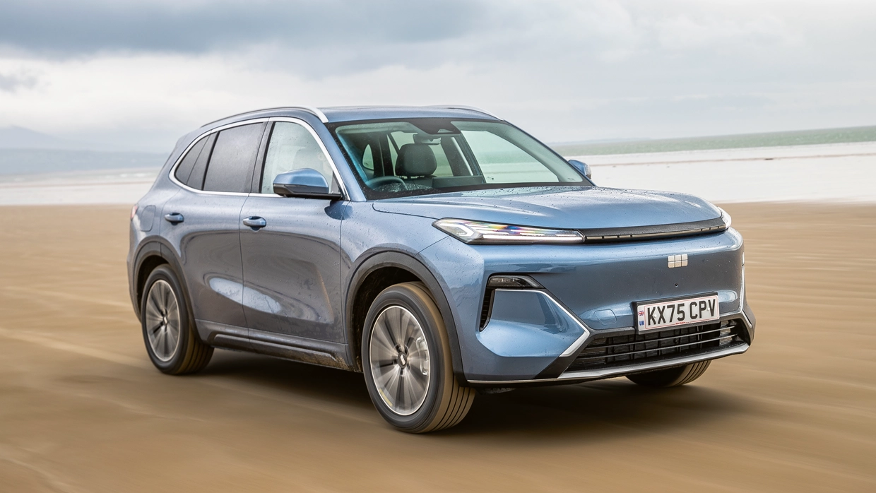 A blue Geely Starray SUV driving across a wide sandy beach.