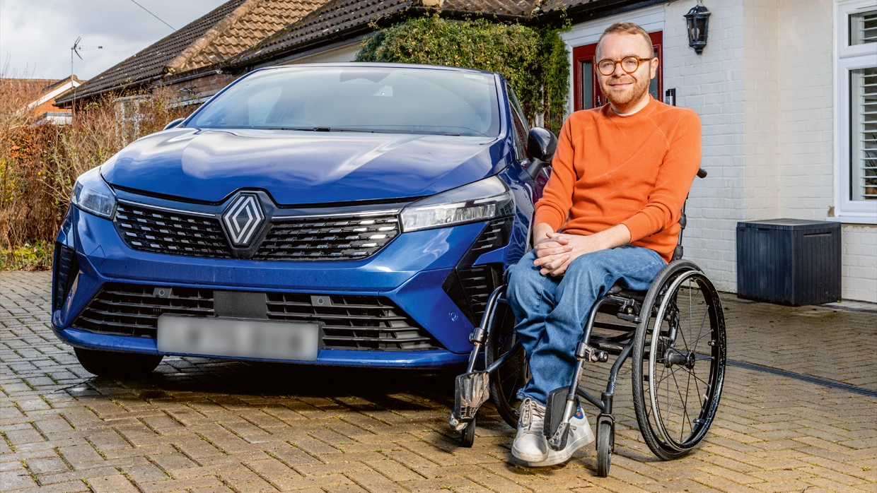 Steven sat in his wheelchair next to his Renault Clio. 
