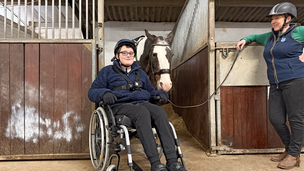 William in a wheelchair next to a horse 