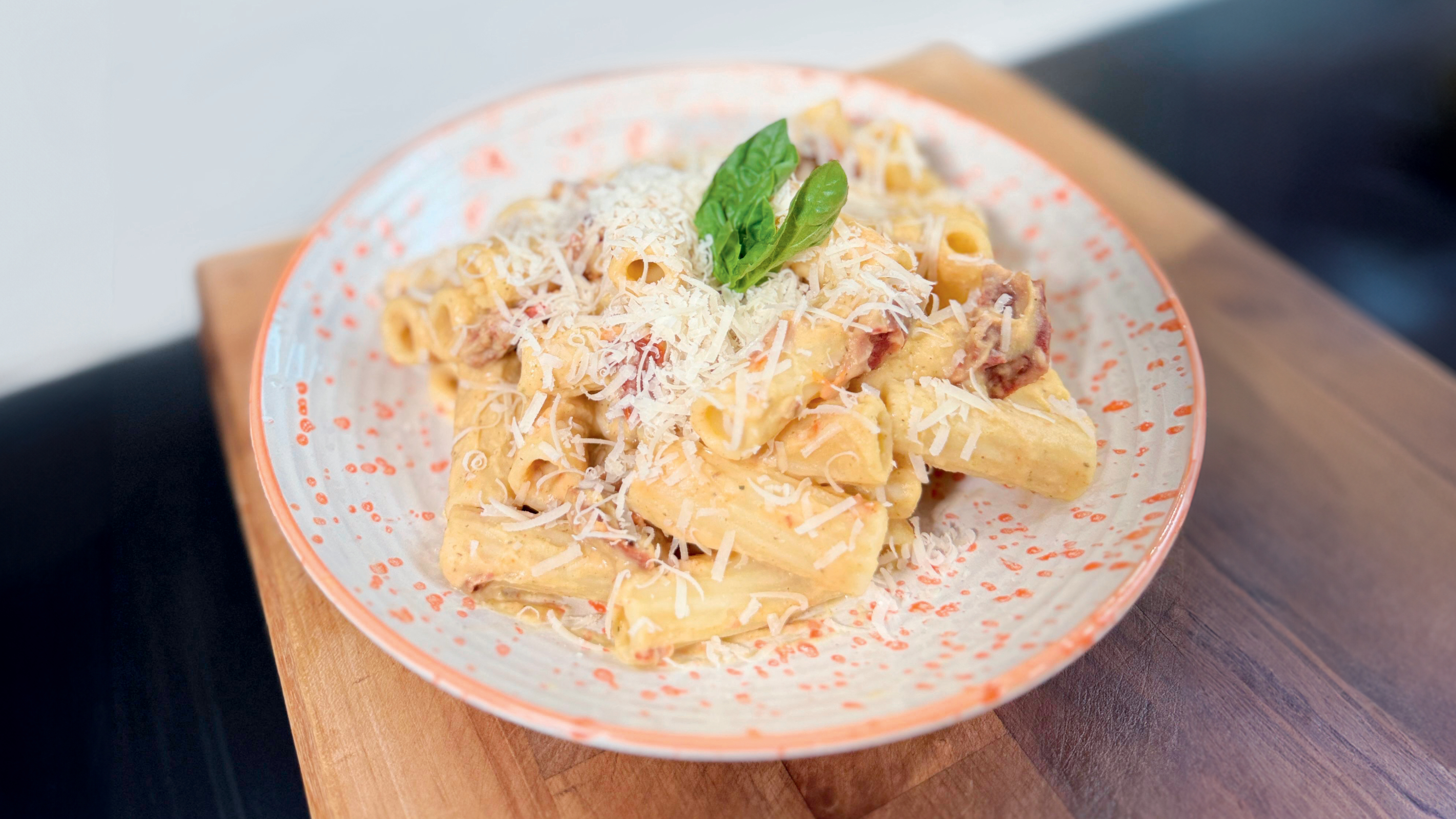 A plate of creamy butter pasta on a wooden table