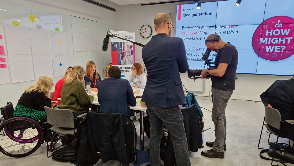Participants, including a wheelchair user, collaborate during an idea generation workshop for the Motability Foundation.