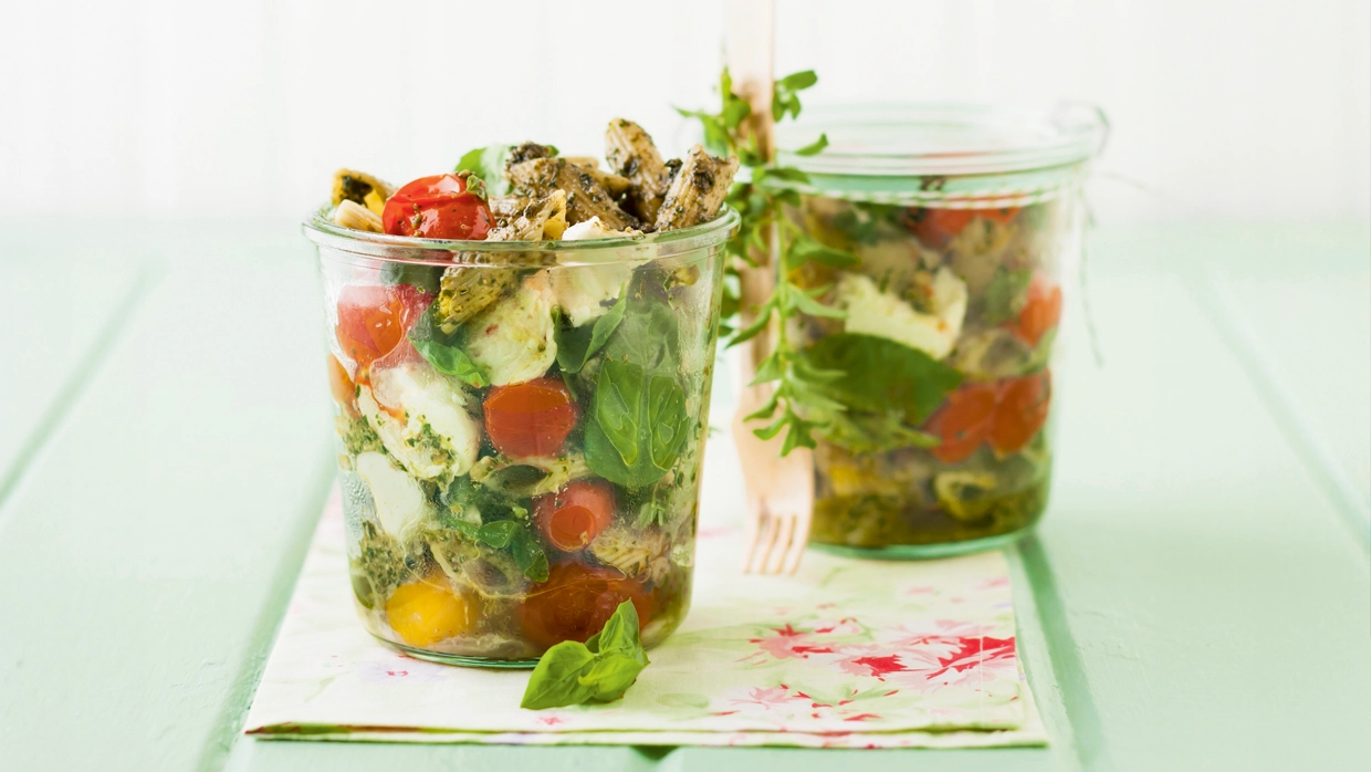 Two servings of penne salad with pesto and mozzarella 