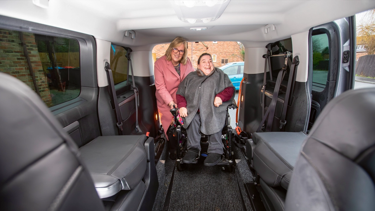 an-adult-woman-in-a-power-wheelchair-and-her-mother-smile-inside-the-spacious-cabin-of-a-silver-wheelchair-accessible-vehicle-wav.webp